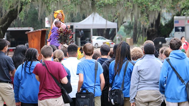 Group of young people watching performer on stage