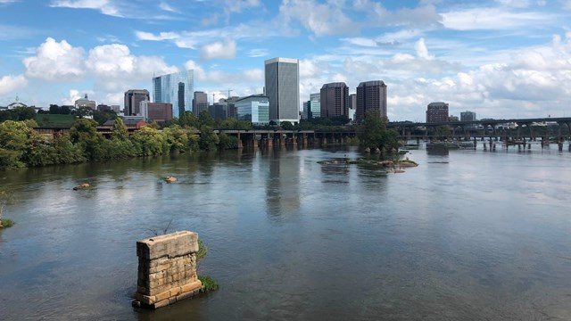 A large river flowing with a city skyline in the distance