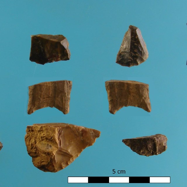 ten stone tool artifacts are laid out with five centimeter ruler. Artifacts range from 5 to 2.5 cm