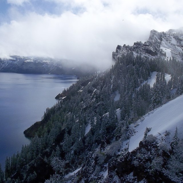 Misty, snowy landscape photo of Crater Lake National Park.
