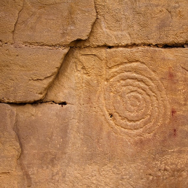 circular petrogrlyph on reddish brown rockface