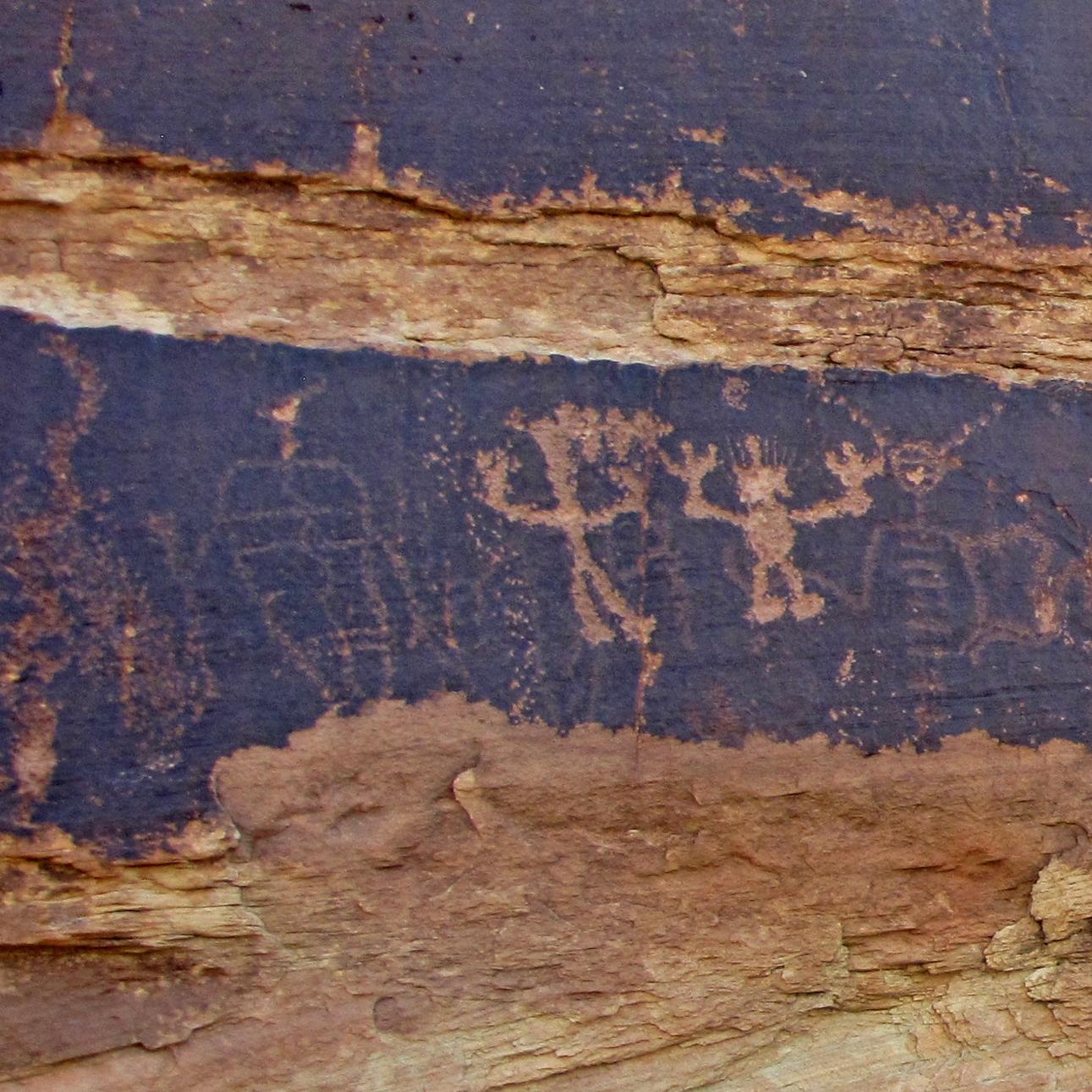 petroglyphs carved into dark red and brown rock