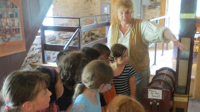 Jeanne, the miller, teaches students how the mill works