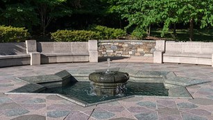 An eight sided star shaped fountain laid into a multicolor stone plaza
