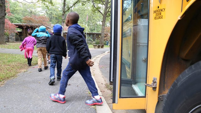 Kids getting off their yellow school bus at the Nature Center