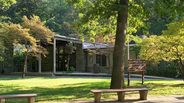 A long, low building surrounded by trees