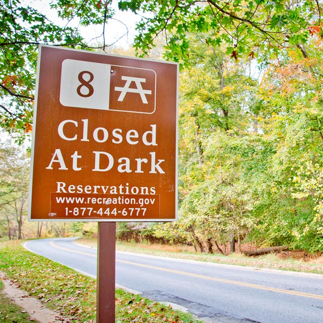 A photo of the picnic grove 8 sign, with the reservations number on the sign. 