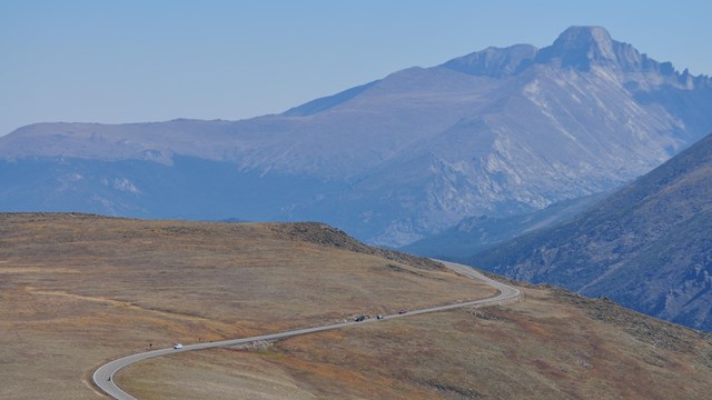 Vehicles are driving on the tundra curves on Trail Ridge Road in summer