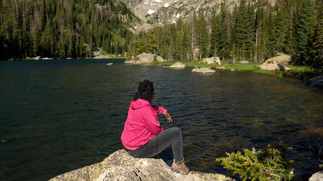 A person is sitting at a lake 