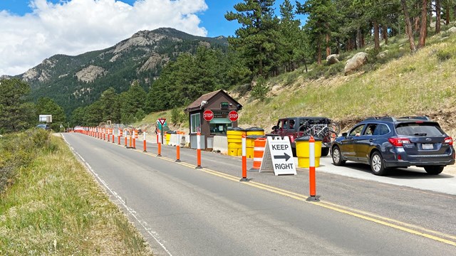 The Fall River Entrance to RMNP is under construction. Orange cones line the lane to the kiosk.