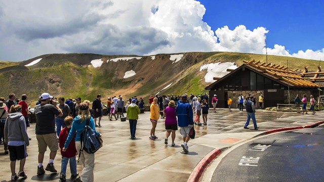Visitors walking near AVC with green tundra ridges extending miles into the background