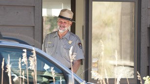 A ranger greets a visitor at a park entrance booth