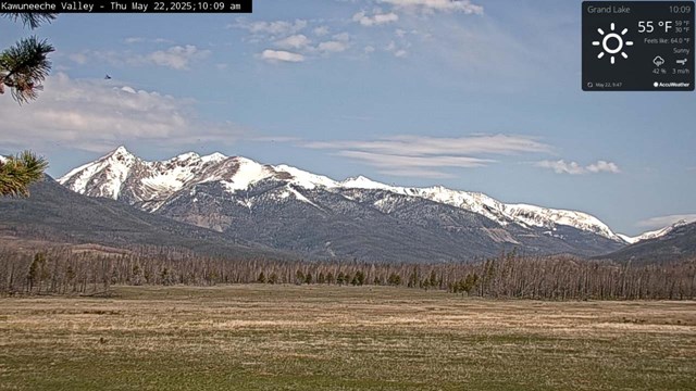View of the Kawuneeche Valley meadow, free of snow. Snow is on the mountain peaks in the distance