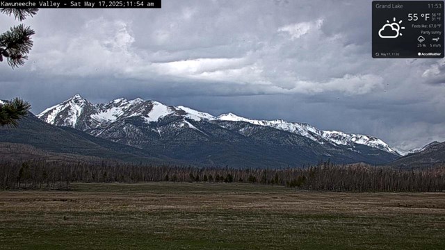 View of the Kawuneeche Valley meadow, free of snow. Snow is on the mountain peaks in the distance