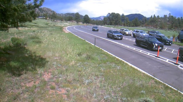 Vehicles are lined up in three lines of traffic to enter the park at Beaver Meadows Entrance