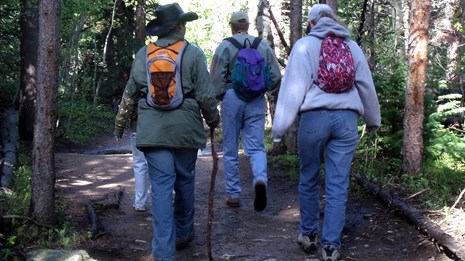 Three people seen talking down a hiking trail