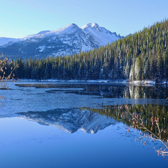 View of an alpine lake and snow-capped peak in early winter