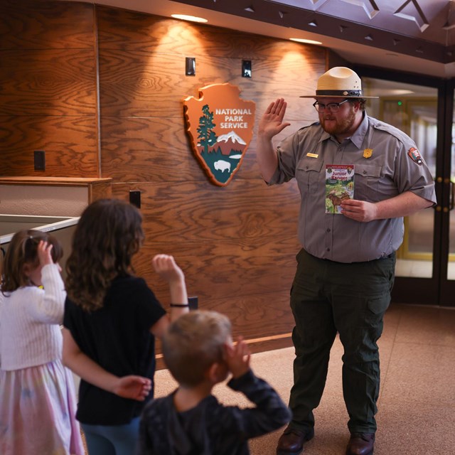 A Park Ranger is swearing in three new Junior Rangers
