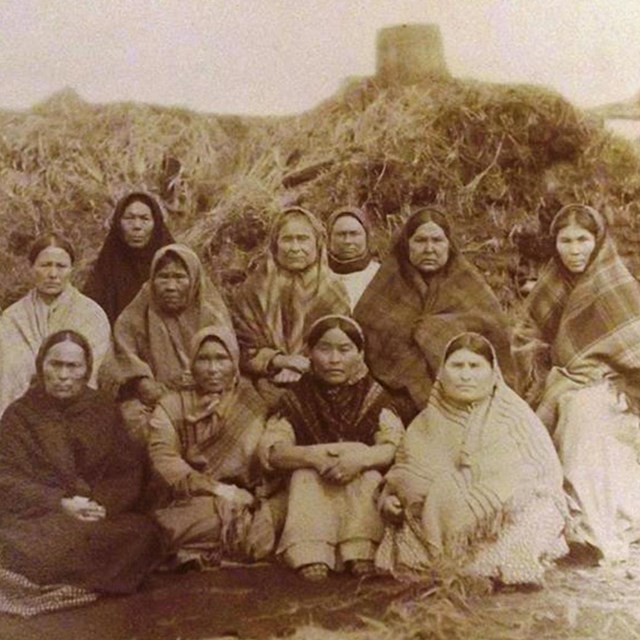 Группа женщин позирует на фоне барабары