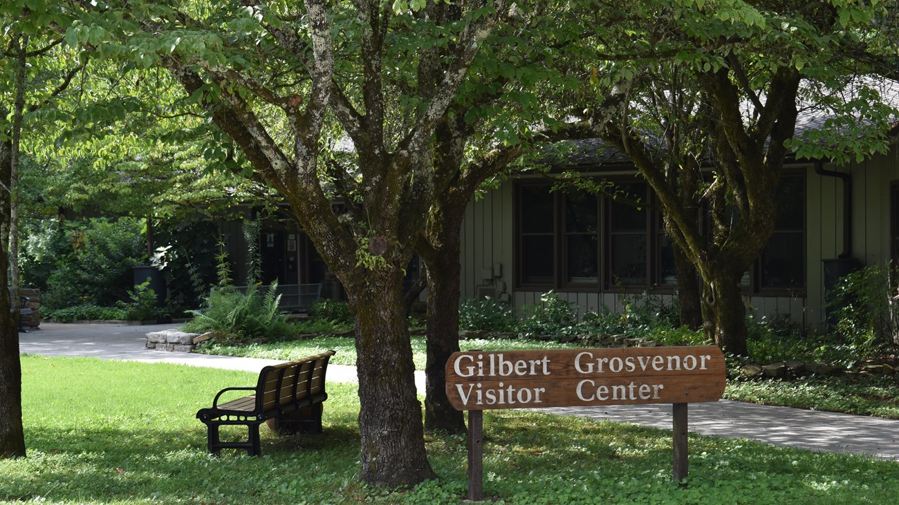 A brown sign labels a building in the background as the Gilbert Grosvenor Visitor Center