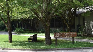 A sign "Gilber Grosvenor / Visitor Center" stands outside building.
