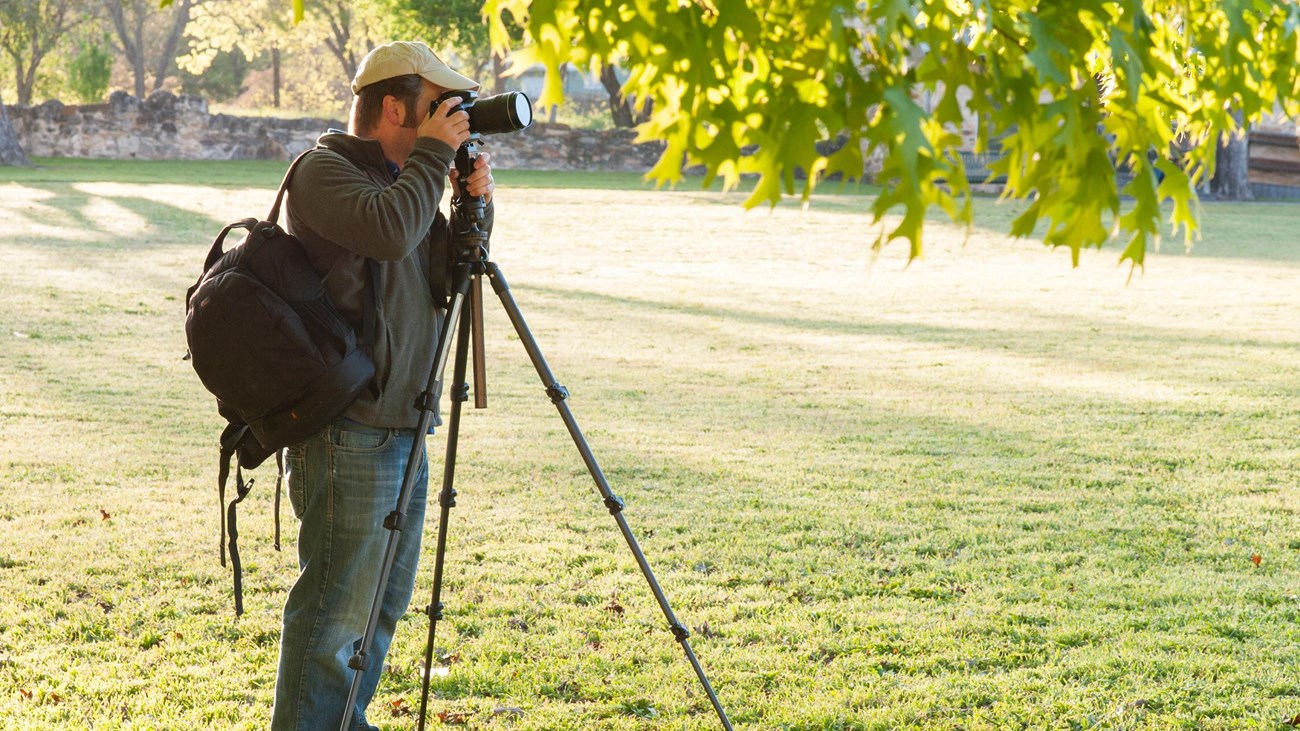 Visitor takes photographs at the park using a camera and tripod.