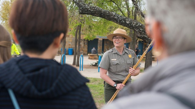 Park Ranger demonstrates the atl atl for a visiting field trip.