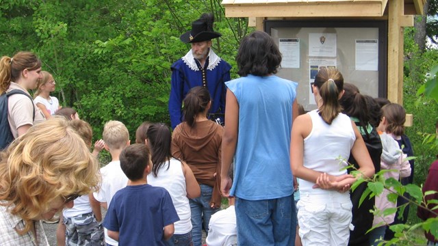 students stand in a half circle in front of a costumed ranger