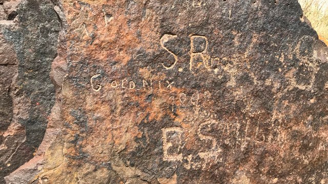 A rock with inscribed names on it.