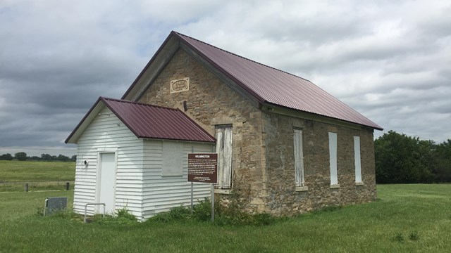 A one room school house set in a farm field.