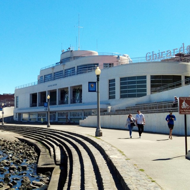 a white building designed to look like an ocean liner ship near a rocky shoreline