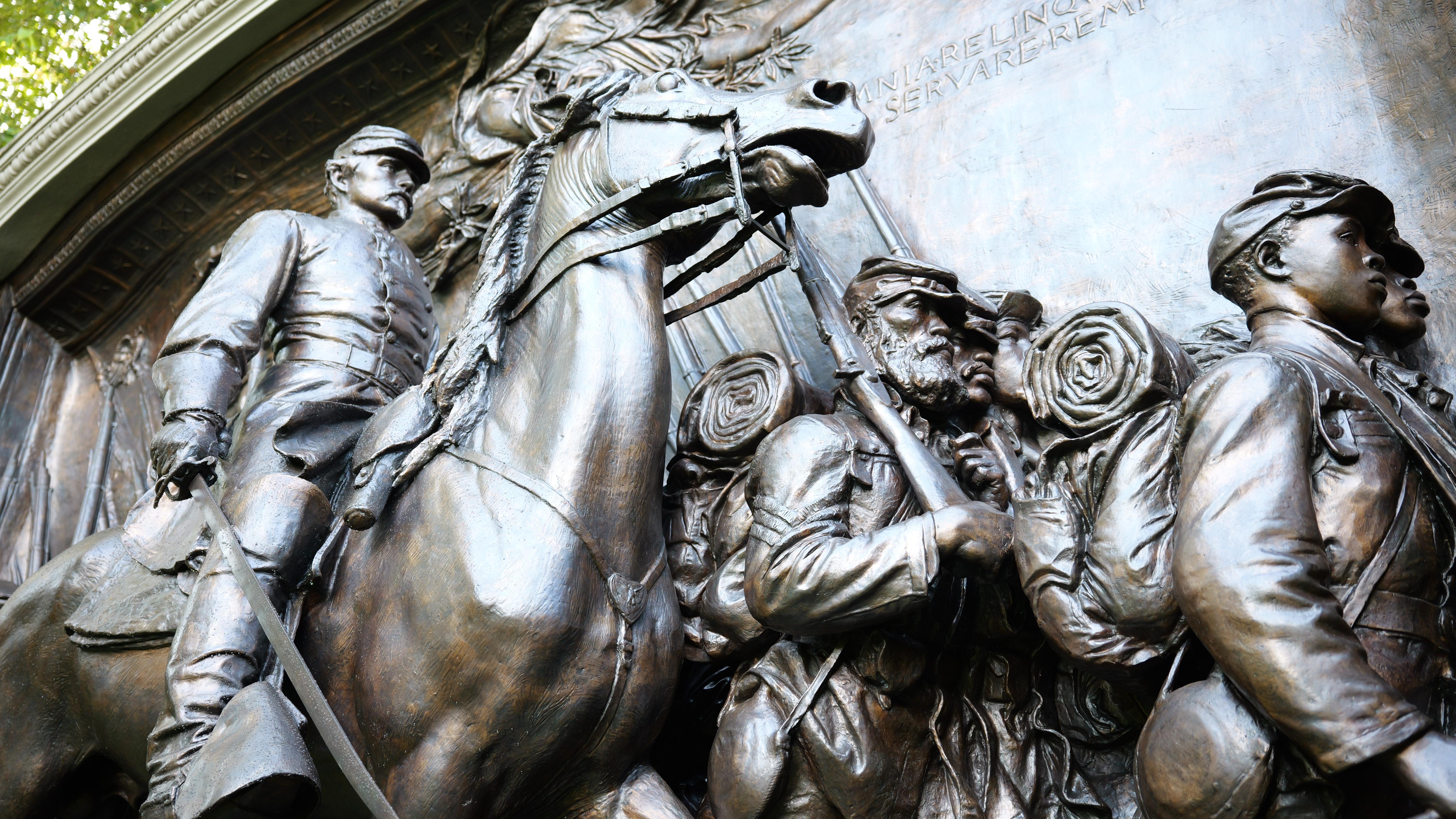 Civil War memorial behind small American flags in ground