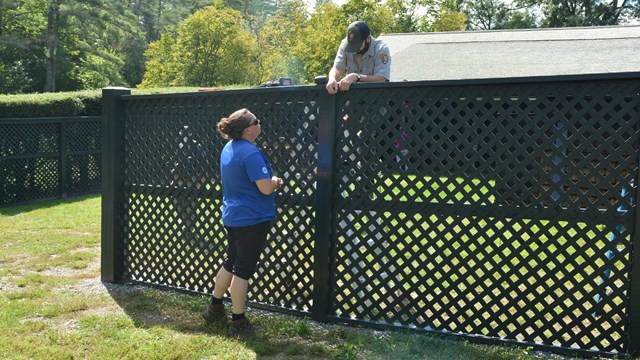 intern and worker complete fence work