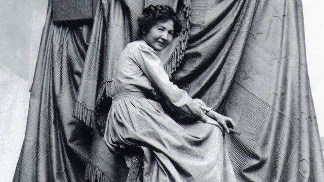 woman seated on ladder behind sculpture of Lincoln