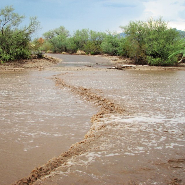 Stormwater flooding desert wash, blocking road