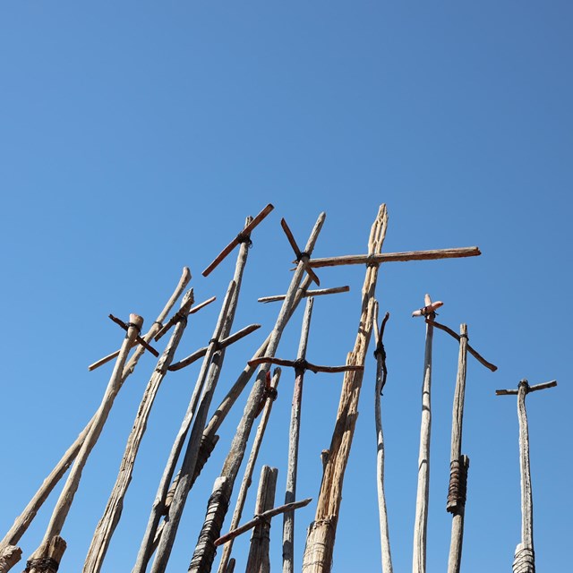 A bright blue sky fills the image, with a bundle of Kui'pads in the lower left.