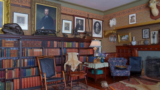 A room with books, portraits, and hunting trophies