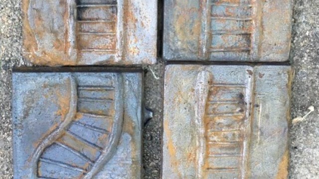 Cast iron squares in a series with train tracks connecting each of them 