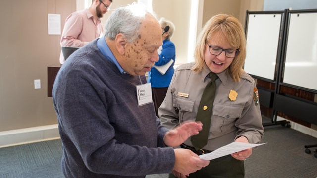 Two people look at a document together. 