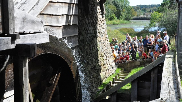 group of visitors watching a waterwheel turn
