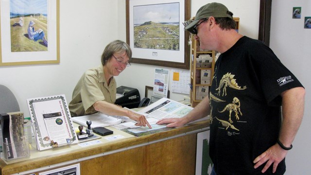 A park volunteer helps a visitor at the front desk.