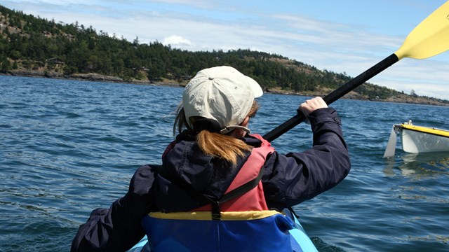 View of person's back while kayaking