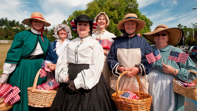 Women dressed in period clothing from the 1800s.