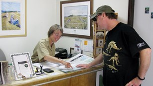 A volunteer-in-park gives directions to a visitor.