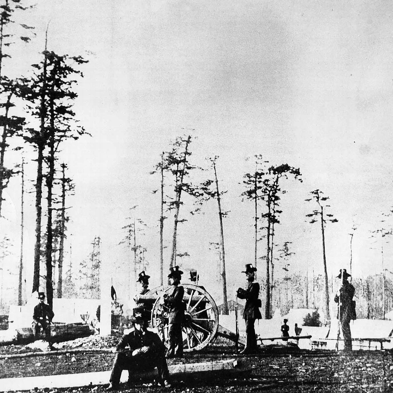 Black and white photo of a group of soldiers next to a cannon