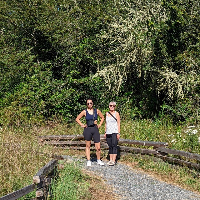 Color photo of two women on a graveled trail