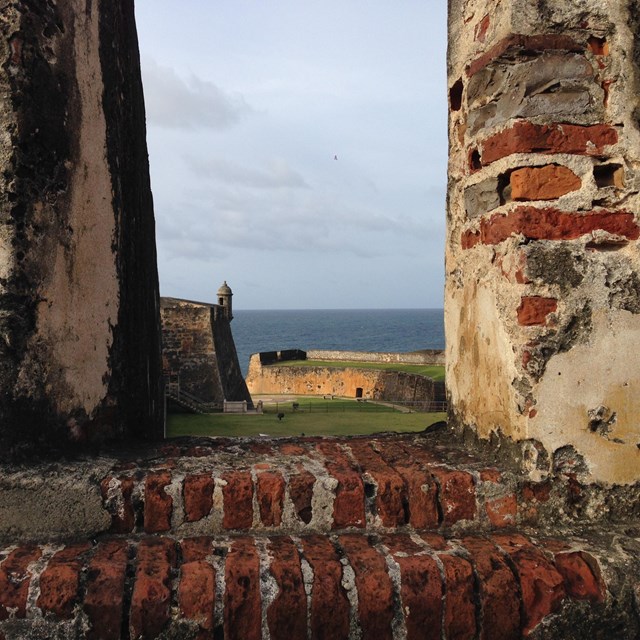 View of sentry box and walls through a higher level cannon embrasure.