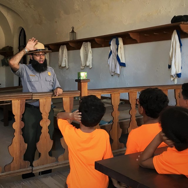 A ranger provides information to a group of students inside a soldier casemate. 