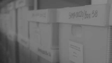 Stacks of white storage boxes with labels.