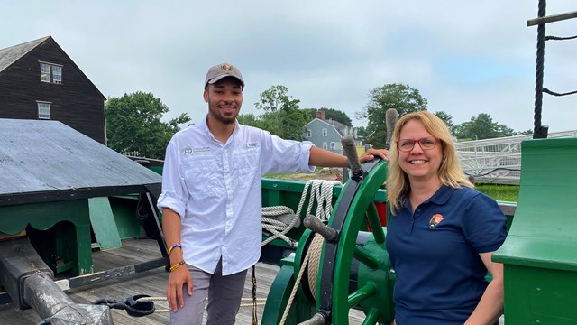 A park ranger and intern stand on the FRIENDSHIP OF SALEM.